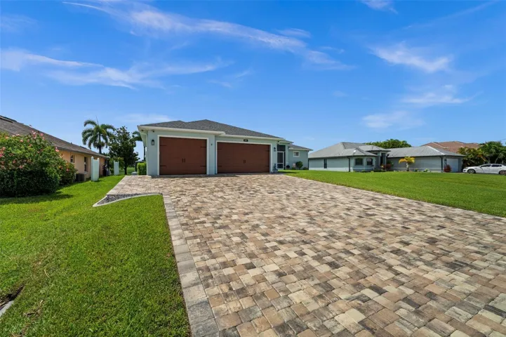 The pavered driveway leads to the elevated home sweet home.