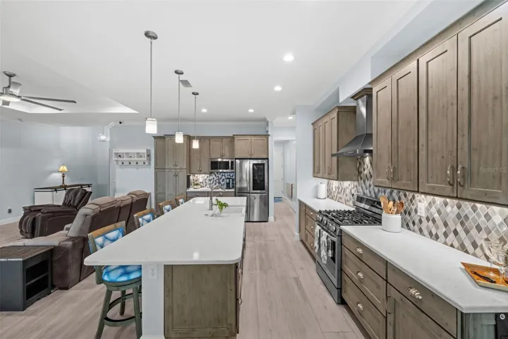 Rounded edge quartz countertops, the tile backsplash, a gas range wired for electric, stainless range hood, pull out cabinetry drawers. Wow!
