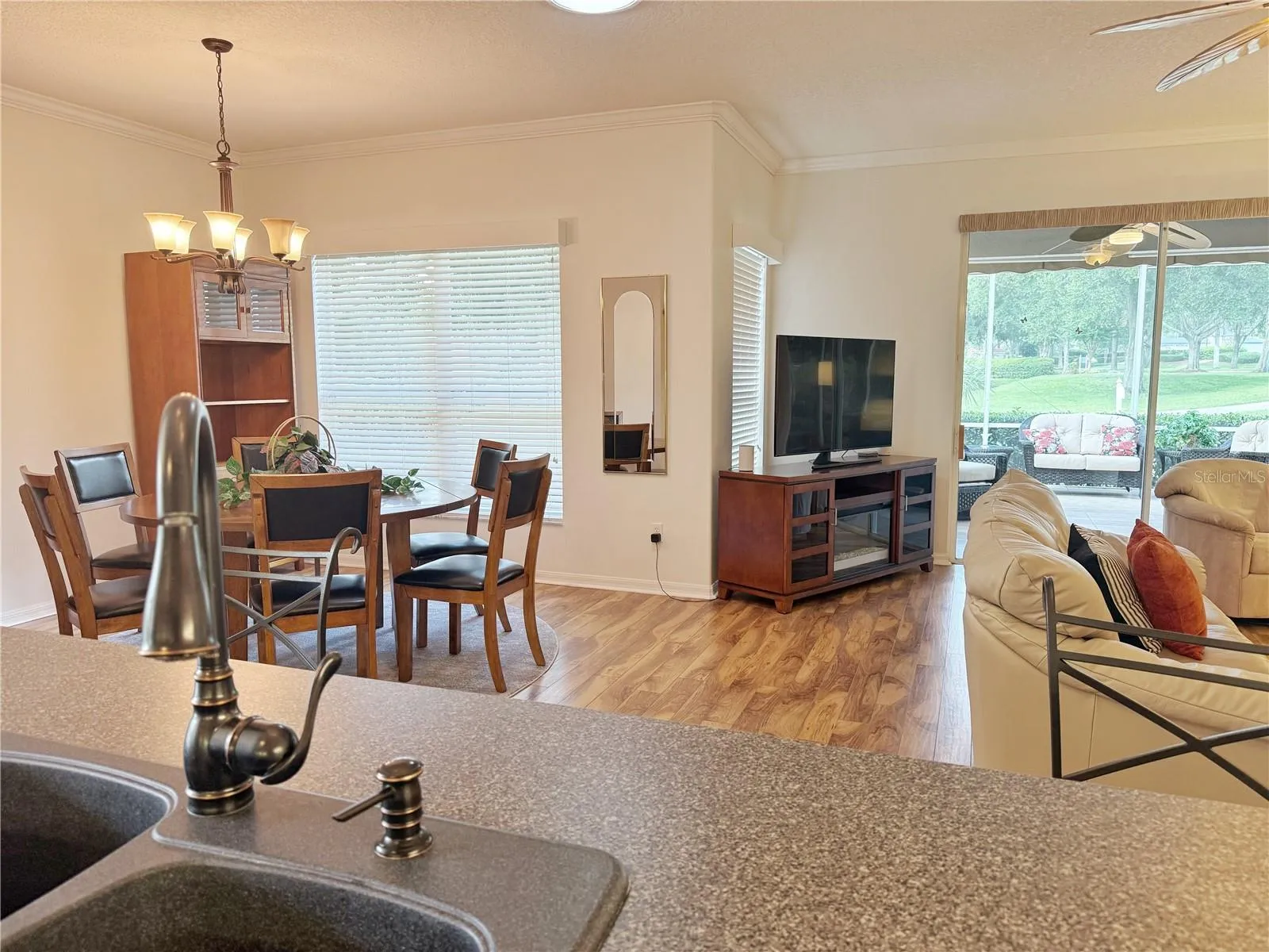 Additional view of Living and Dining room with golf course view and screened in and covered lanai