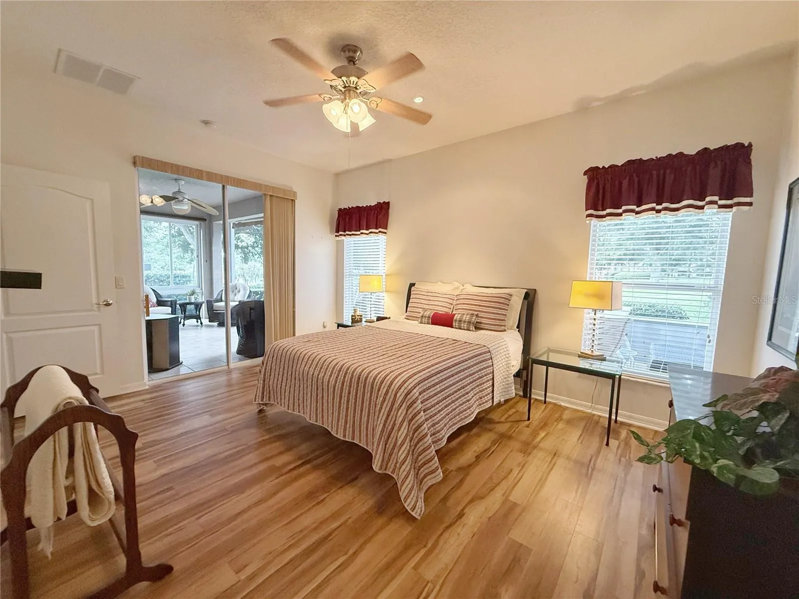 Additional view of Primary Bedroom showing sliding doors onto the covered and screened in lanai and golf course view