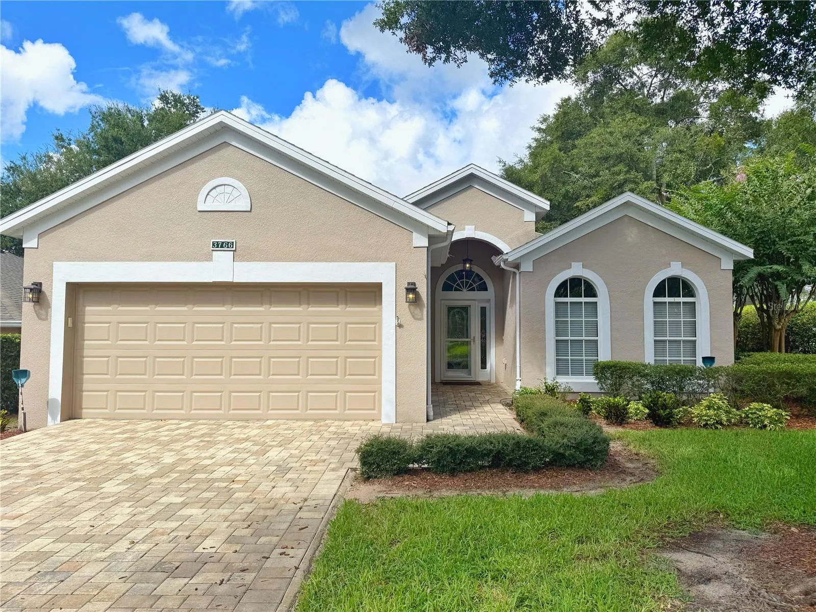Front Exterior with Paver driveway, glass/screen storm door, Eyched glass front Entry door, gutters