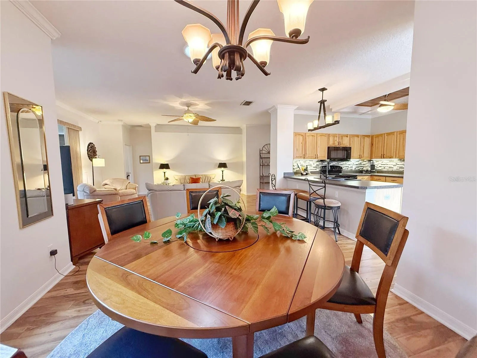 Dining room with view of Kitchen and Living room, laminate flooring, updated fixtures, crown molding, open floor plan and a view of the Golf course