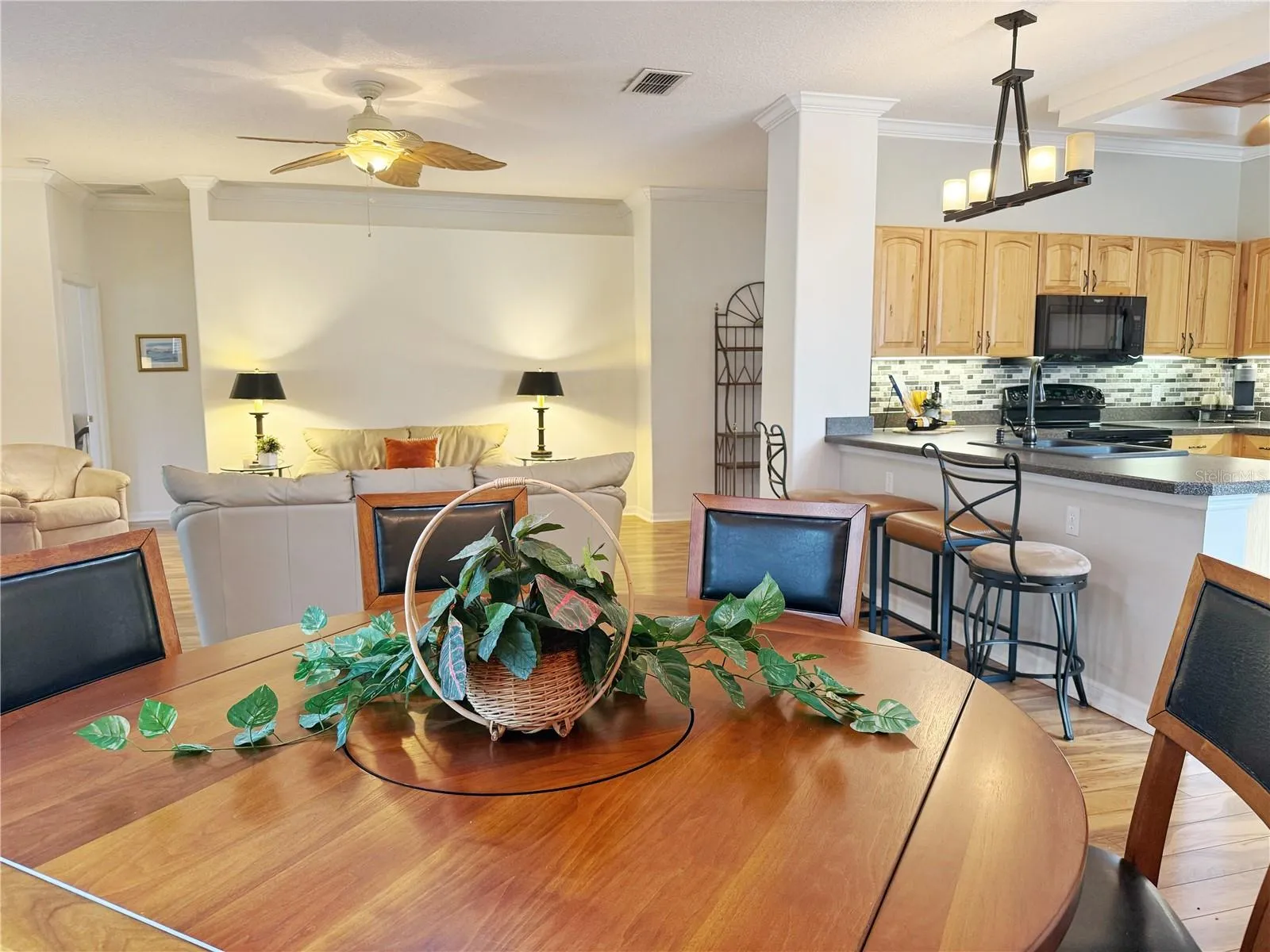 Additional view from Dining room of Kitchen and Living room, crown molding, laminate flooring, golf course view, open floor plan