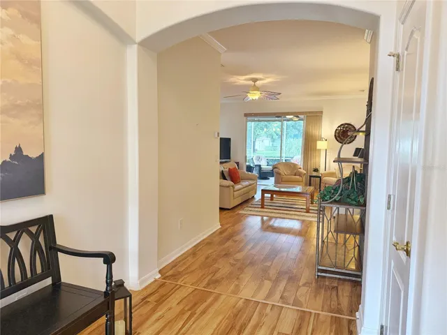 Front Entry with view of golf course and living room, laminate flooring, crown molding, updated fixtures, high ceiling