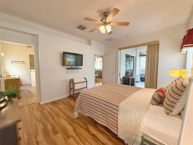 Primary Bedroom with en suite bathroom, walk in closet, sliding glass doors onto lanai and decorative shelf