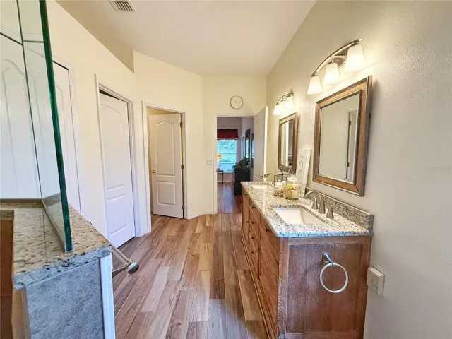 Additional Primary Bathroom view with dual sinks, water closet pantry, walk in shower heads, ceramic tile flooring, decorative shelf and walk in closet