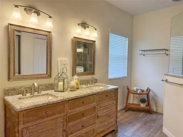 Primary Bathroom with ceramic tile flooring, dual sinks, walk in shower with multiple shower heads, water closet, walk in closet