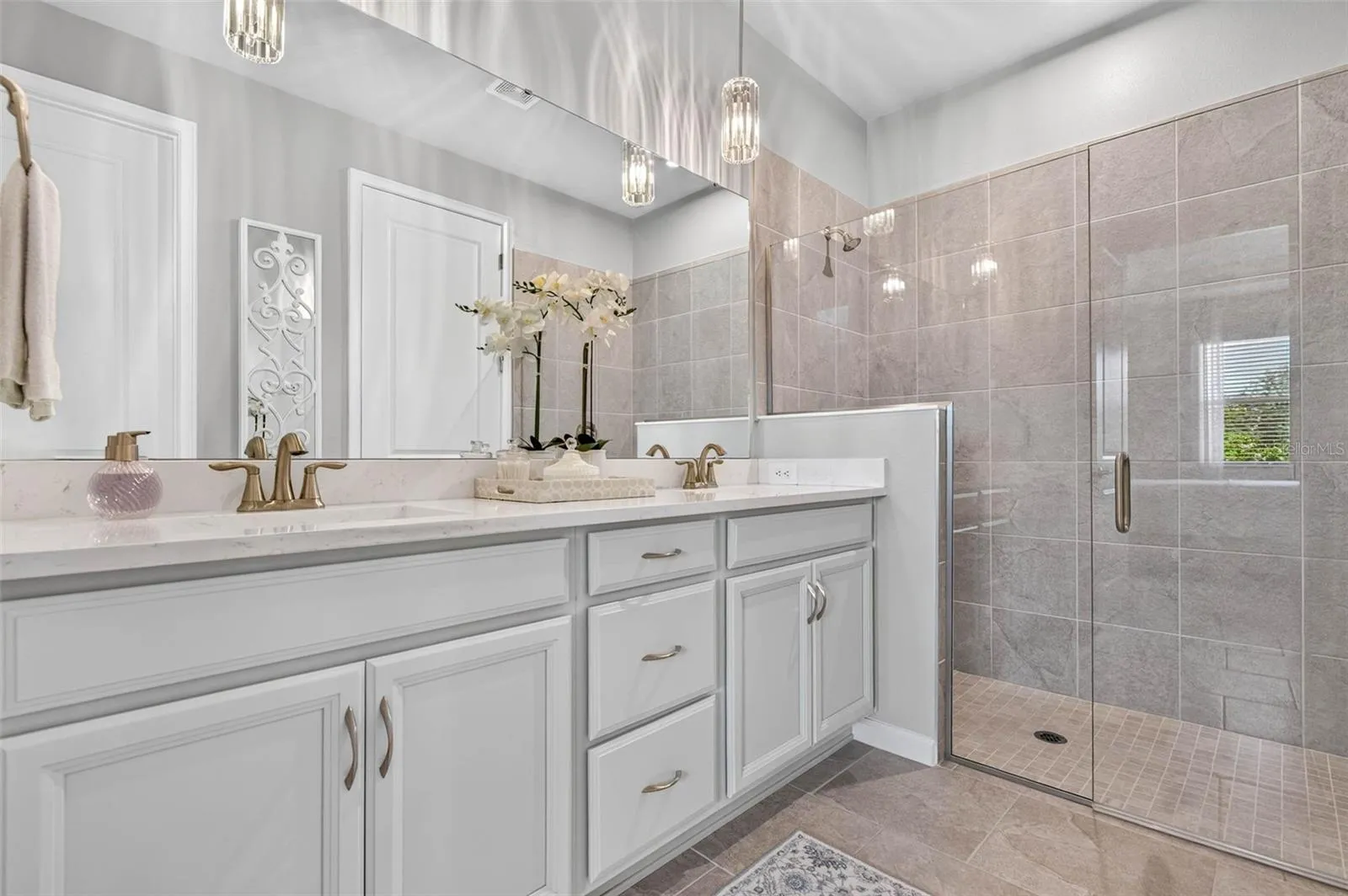 Long vanity with double undermount sinks, bank of drawers and elegant lighting