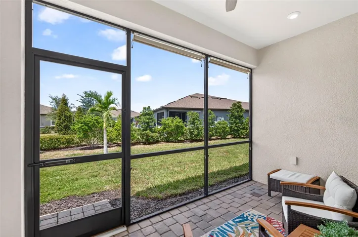 Screened lanai with landscaped view and roll down shades