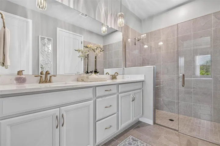 Long vanity with double undermount sinks, bank of drawers and elegant lighting