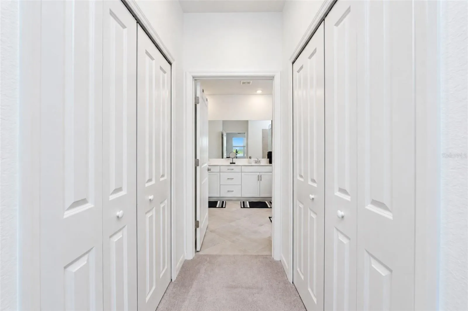 Hallway to Primary Bath Dual Walk-in Closets