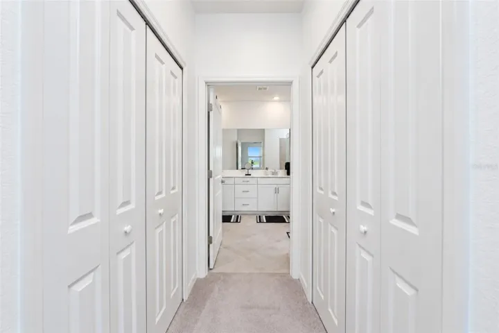 Hallway to Primary Bath Dual Walk-in Closets