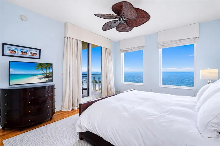 ... Primary / Master Bedroom Suite Looking out towards Gulf.. Wake up in Paradise.. Wood Floors - Custom Black out Drapes - Newer Fan..Balcony Access Thru Sliders.