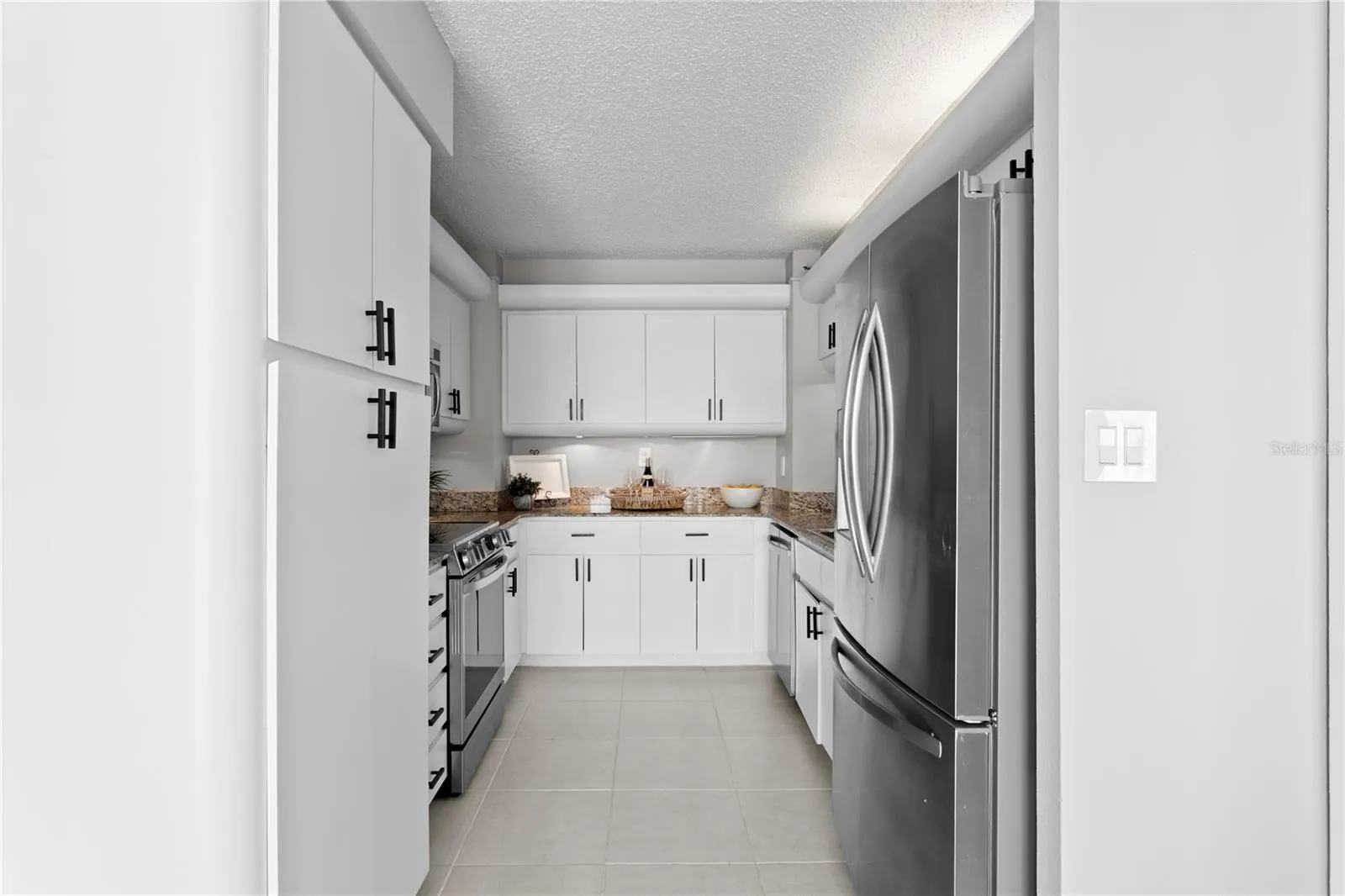 The well-appointed kitchen offers abundant cabinetry, and stainless steel appliances.