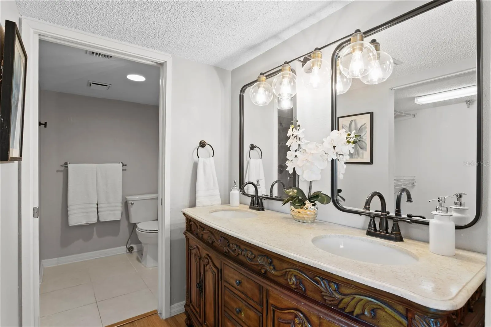 The updated primary bath features dual vanities and a walk-in shower.