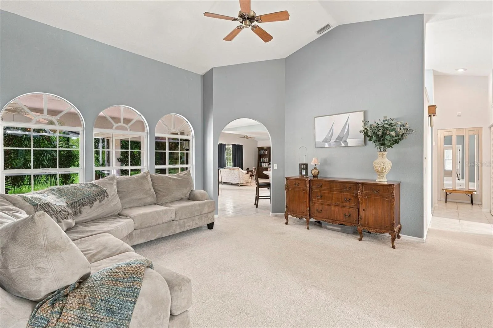 Inviting Living Space with an Open Layout, High Ceiling and Arched Windows
