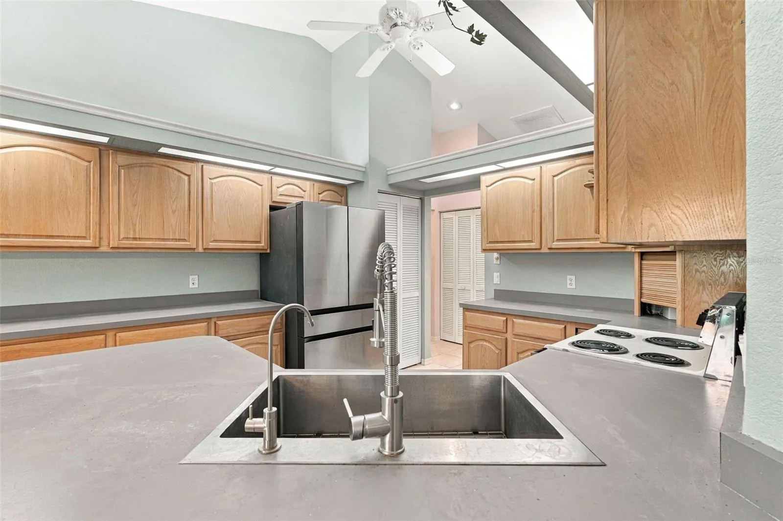 Kitchen Features Vaulted Ceiling and Fan