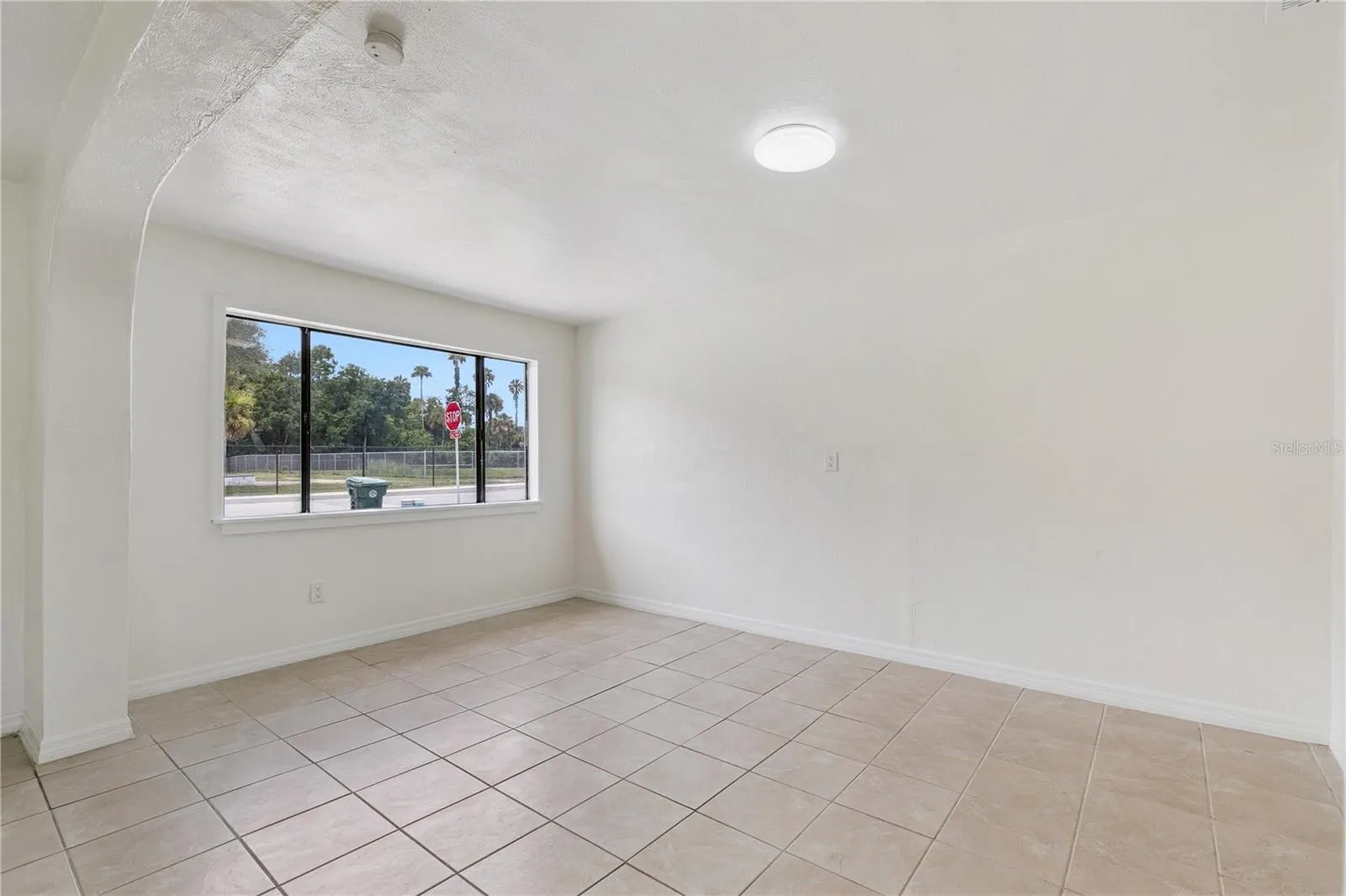 Bright and Spacious Living Area with Tile Flooring and Natural Light