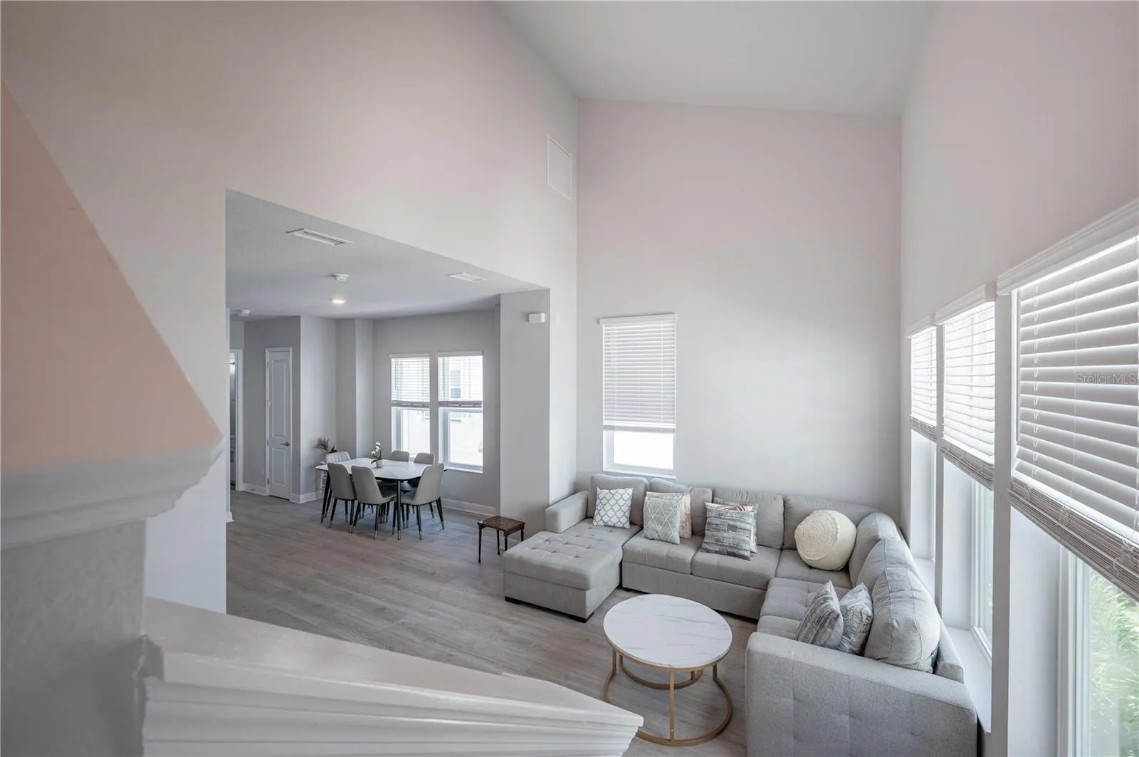 Heading upstairs to the primary suite and laundry room...Notice the high ceiling in the living room...