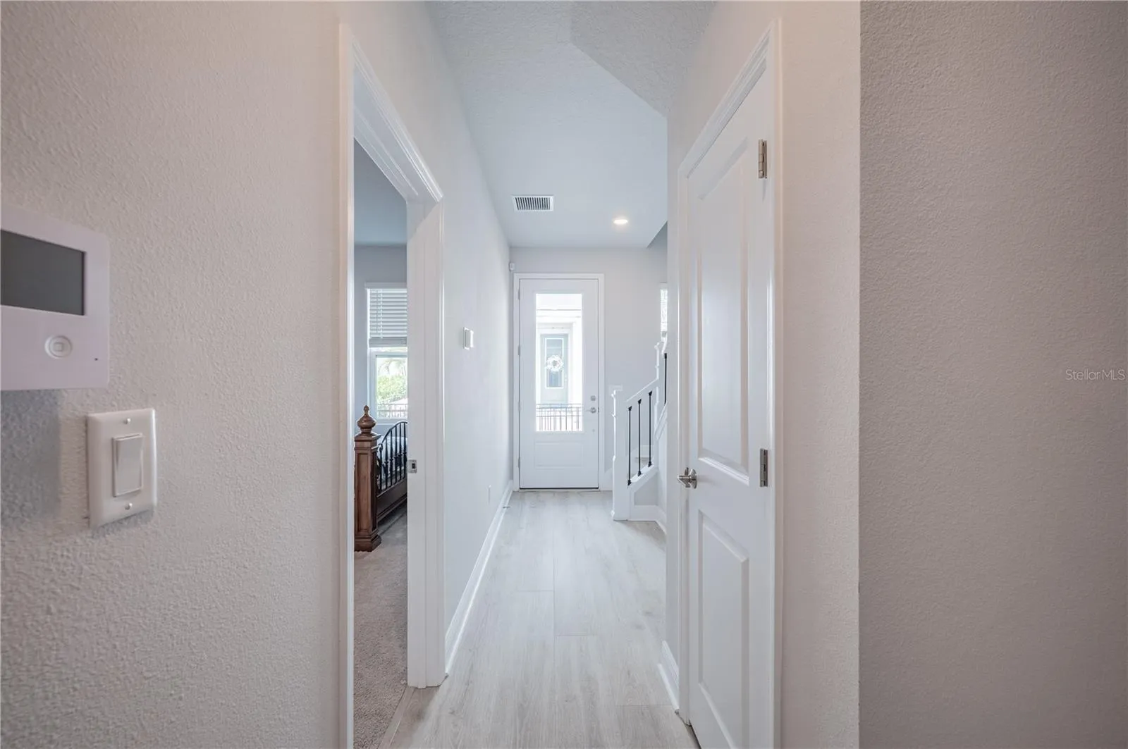 All the way back down to the first floor. Looking out the front door.  Staircase on the right. Let's check out the bedroom on the left.