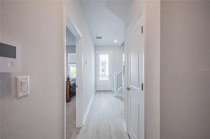 All the way back down to the first floor. Looking out the front door.  Staircase on the right. Let's check out the bedroom on the left.