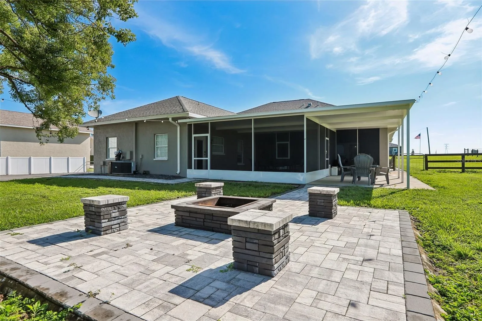 Back of home with beautiful pavers, seating area and fire pit