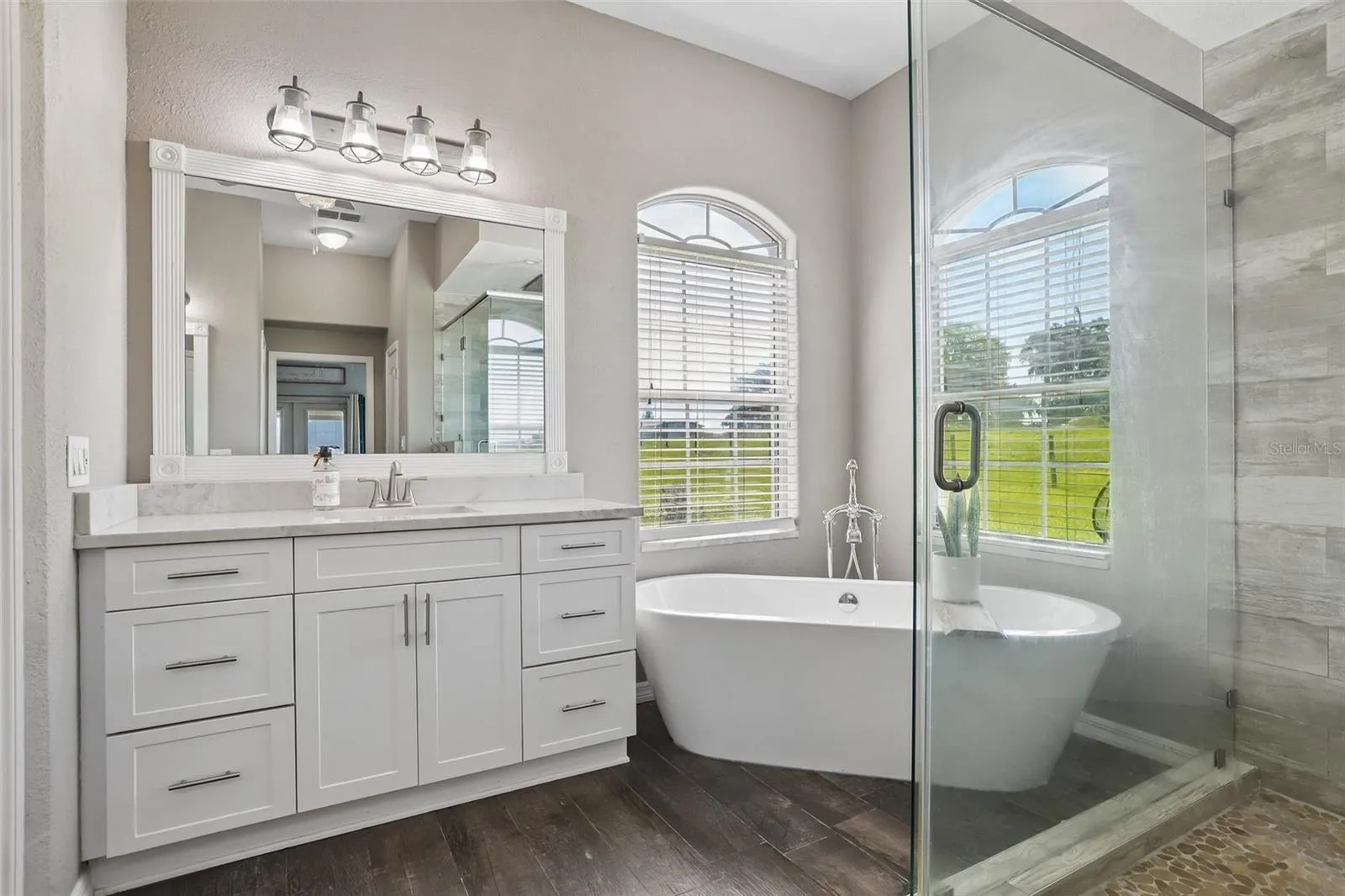 Primary Bathroom with dual vanities, makeup area,  soaking tub and new seamless shower glass