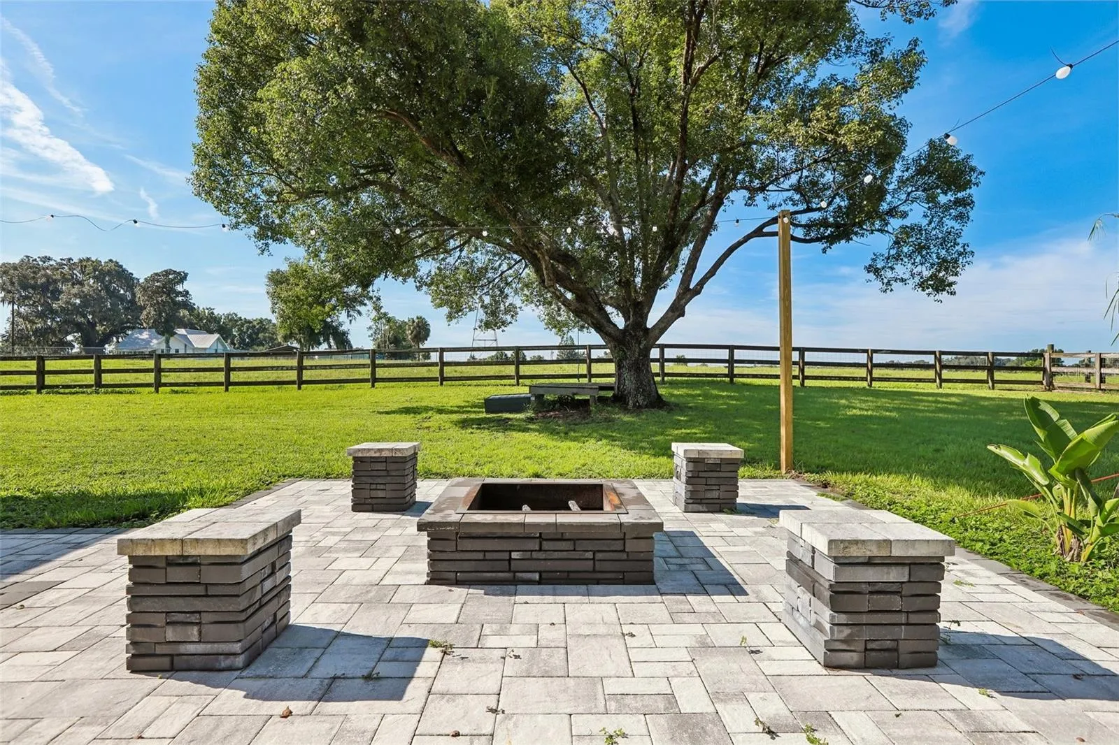 Back of home with beautiful pavers, seating area and fire pit