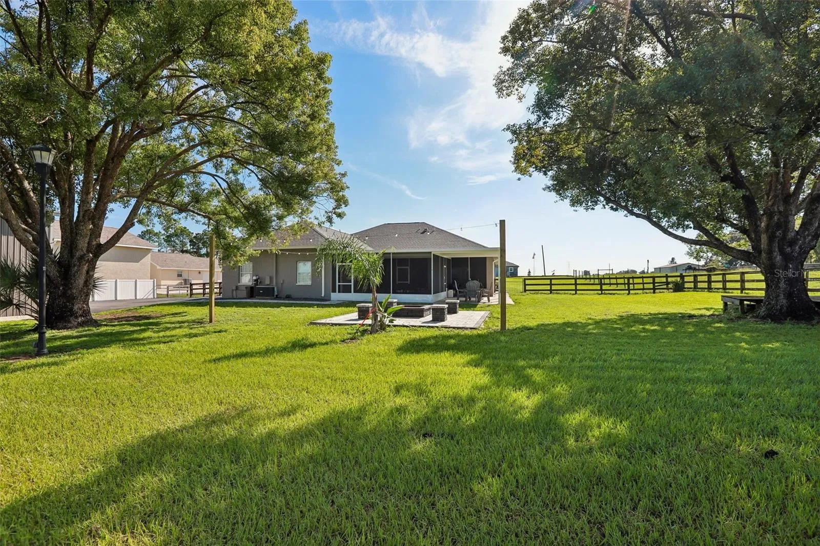 Back of home with beautiful pavers, seating area and fire pit