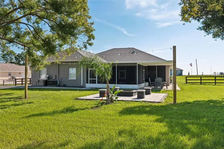 Back of home with beautiful pavers, seating area and fire pit