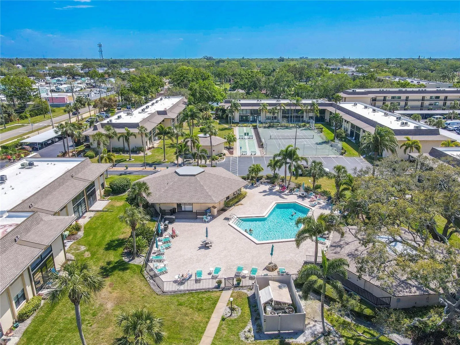 The community pool is surrounded by a broad deck with plenty of seating, while tennis and other court amenities sit just beyond, all grouped together in the heart of Villas de Golf.