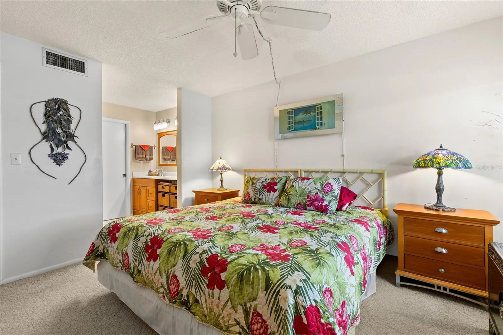 The primary bedroom connects directly to its ensuite bath, with neutral carpeting, a ceiling fan and enough room for a substantial bedroom set without feeling tight.