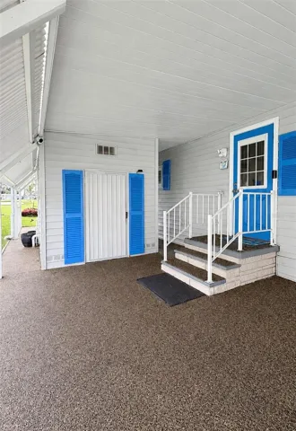side door entrance and river rock driveway
