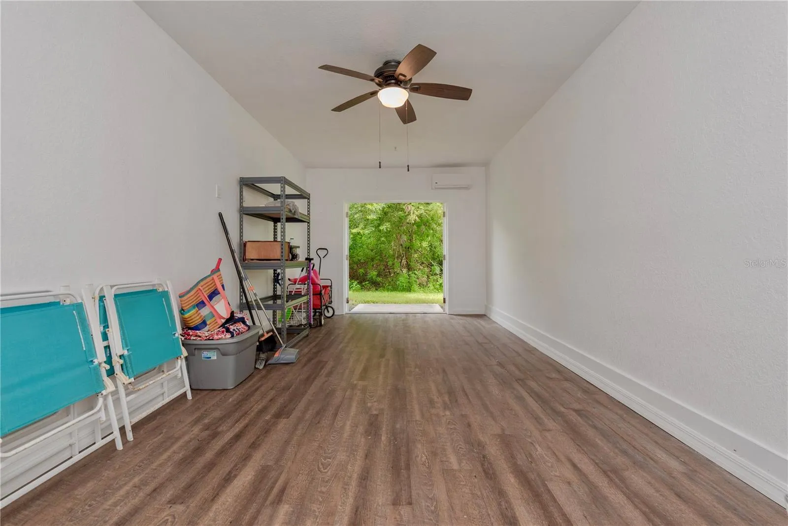 Downstairs storage room has French doors leading to a small patio and has a tree view.