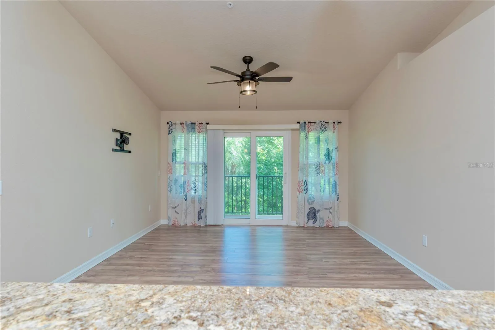 French doors leading to the covered balcony with view of trees.