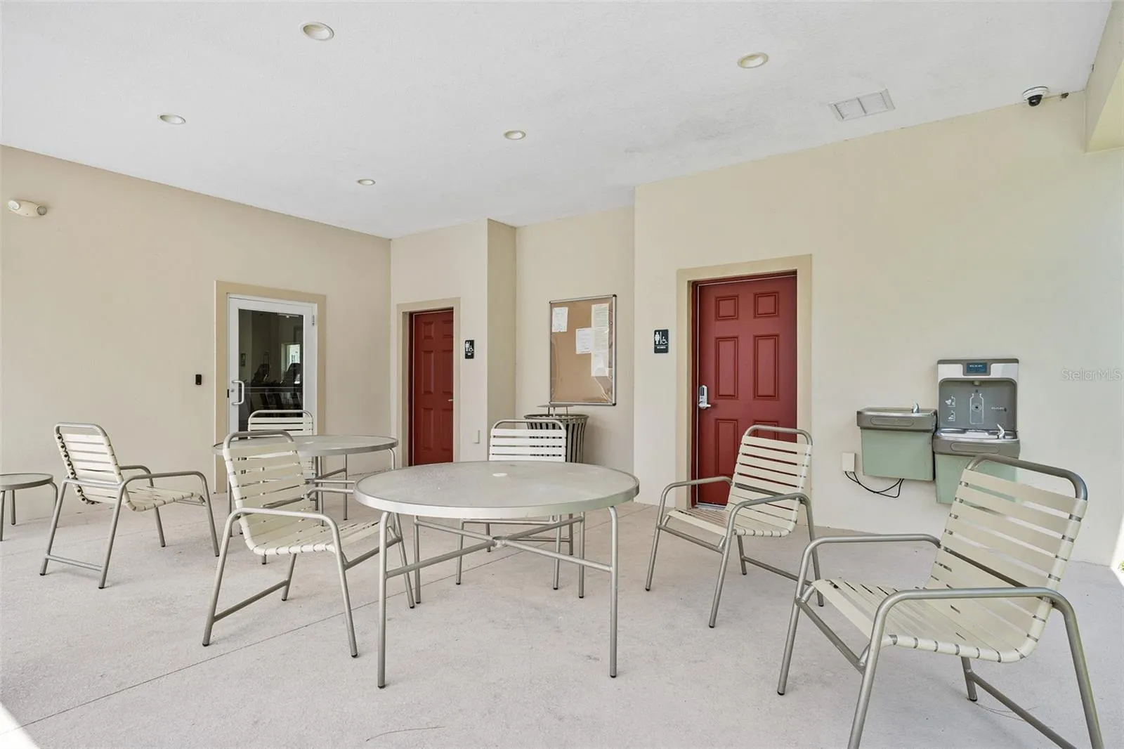 Community seating near pool, access to gym and bathrooms in background