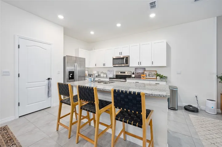 Island with barstool seating, pantry door