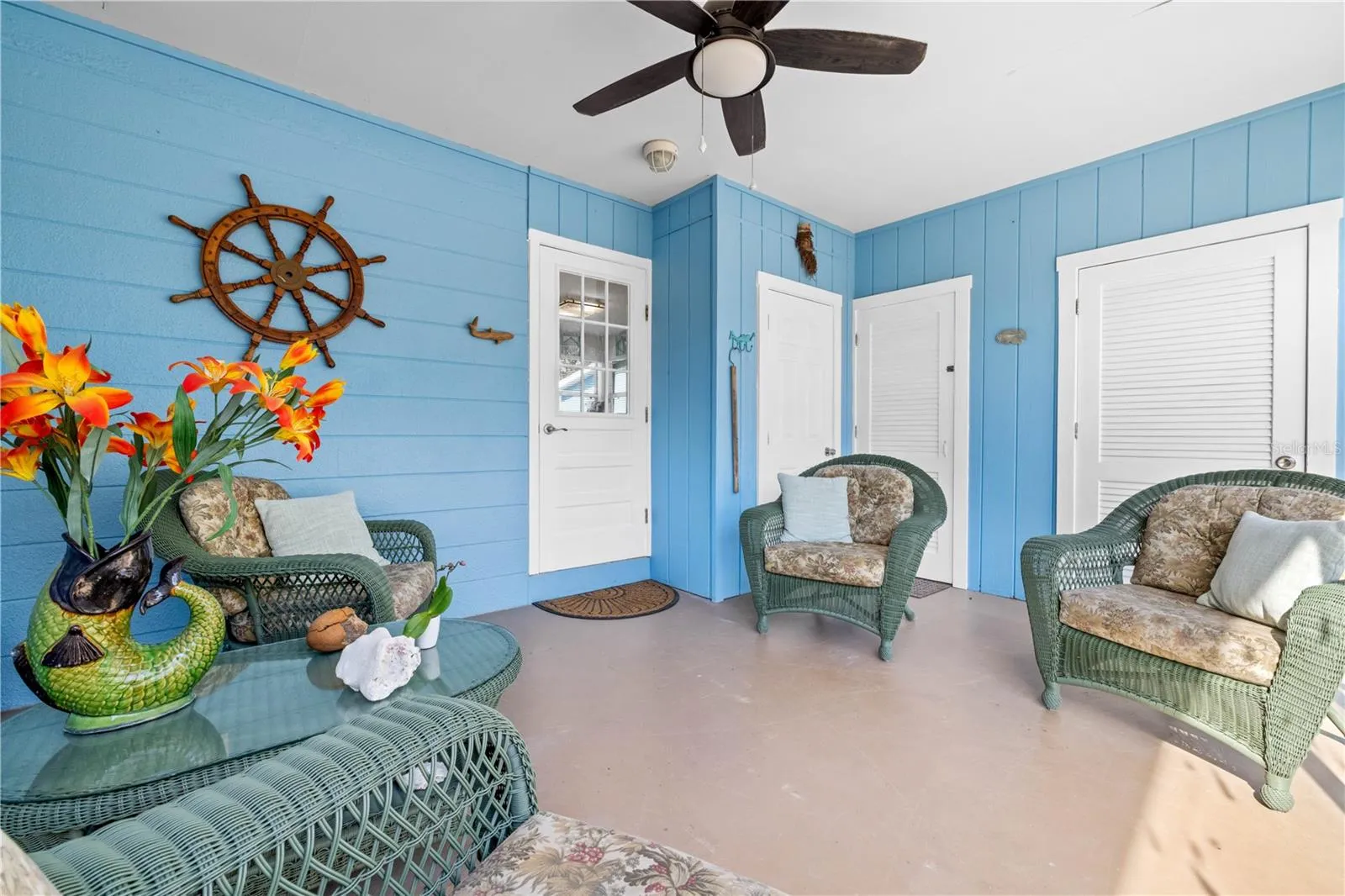 Here is another view of the lanai.  The glass door leads into the house.  The other three doors open to extra closet space, and outdoor shower and the laundry.