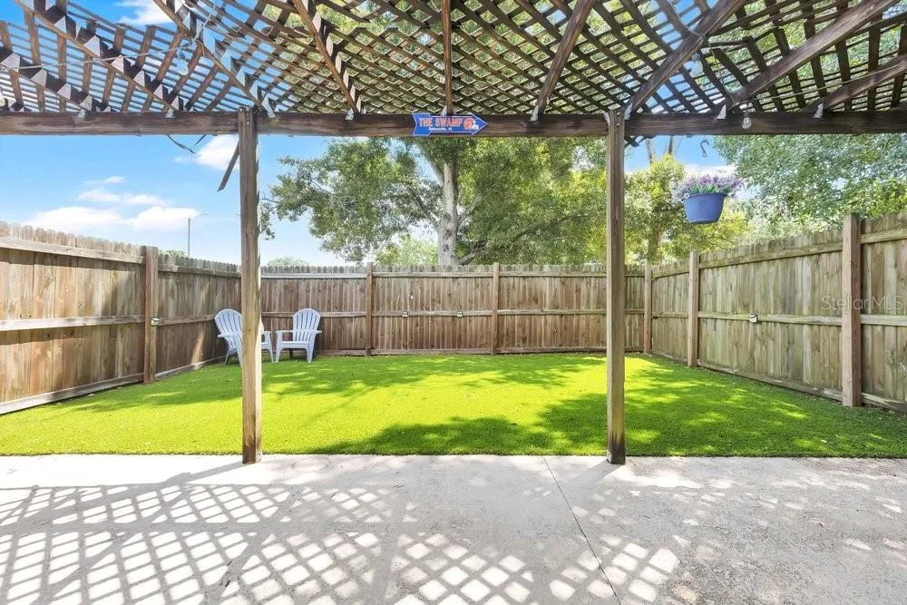 Private fenced yard area with artificial turf