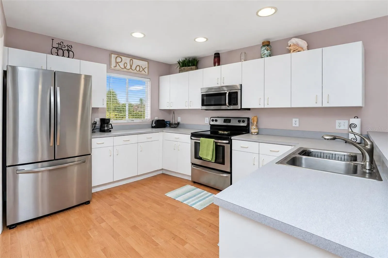 The kitchen features a Samsung French door refrigerator, a Frigidaire microwave, smooth-top stove and dishwasher.