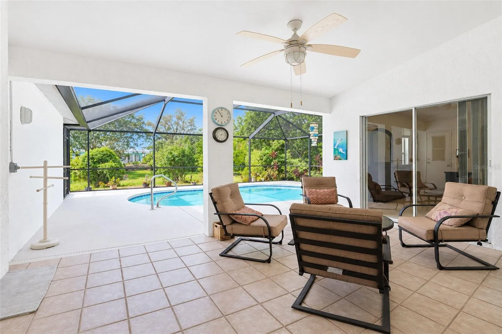 The covered lanai features tiled flooring and a ceiling fan.