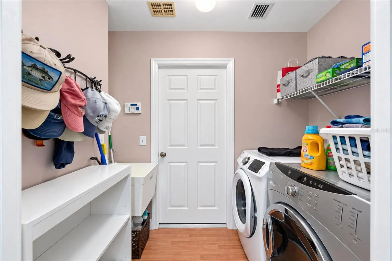 The laundry room features a built in utility tub, a front load Samsung washer and a front load GE dryer.