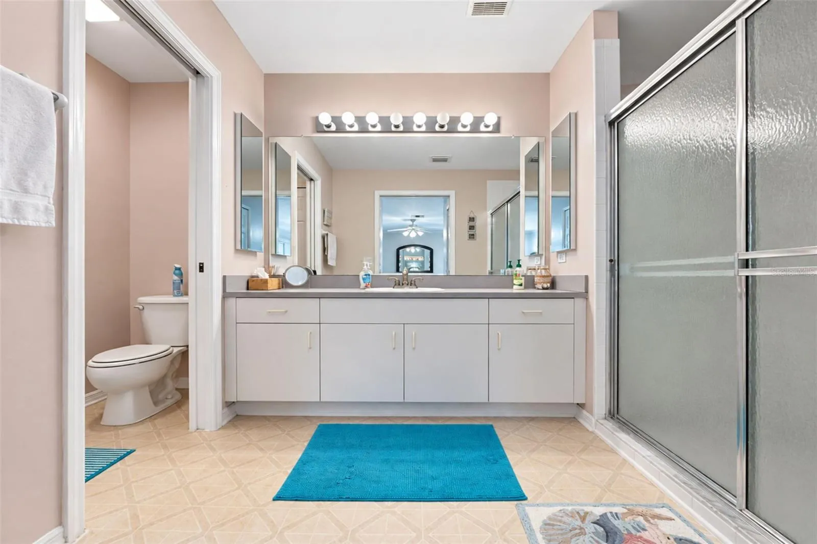 The en-suite bathroom features vinyl flooring, a separate privacy commode and vanity with ample counterspace & storage.