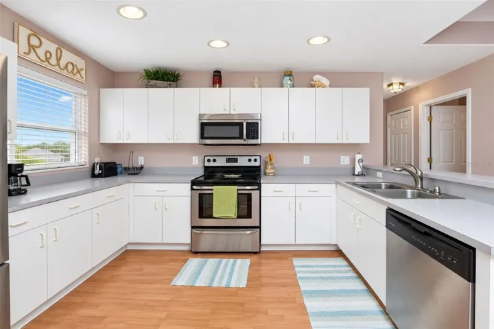 The kitchen has laminate flooring, a window for natural light and plenty of cabinetry for storage.