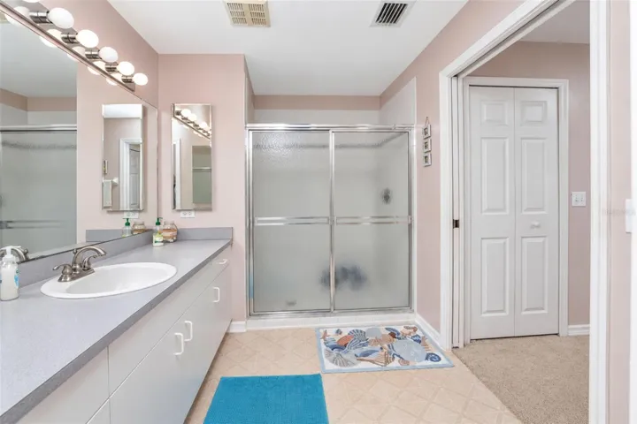 The en-suite bathroom has a step in shower with sliding glass doors.