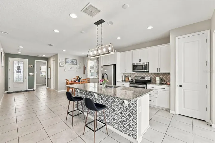 Kitchen + Dining, looking at front door, first bedroom and full bath