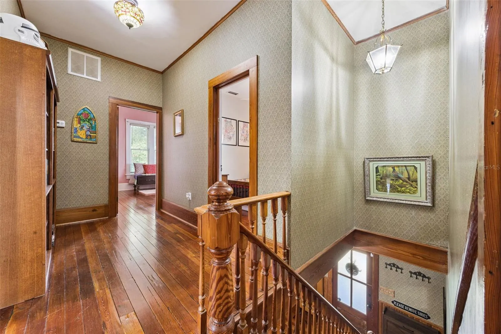 Upstairs, original floors and millwork continue through a spacious central landing connecting the bedroom wing.