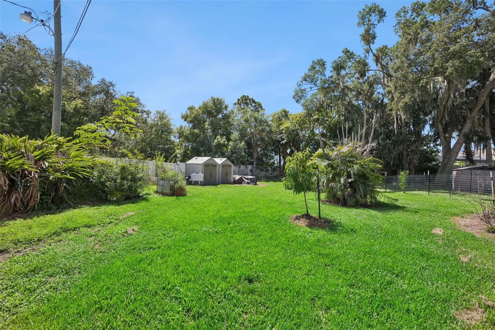 Expansive green space, established garden areas and outbuildings add to the property's flexibility and homestead appeal.