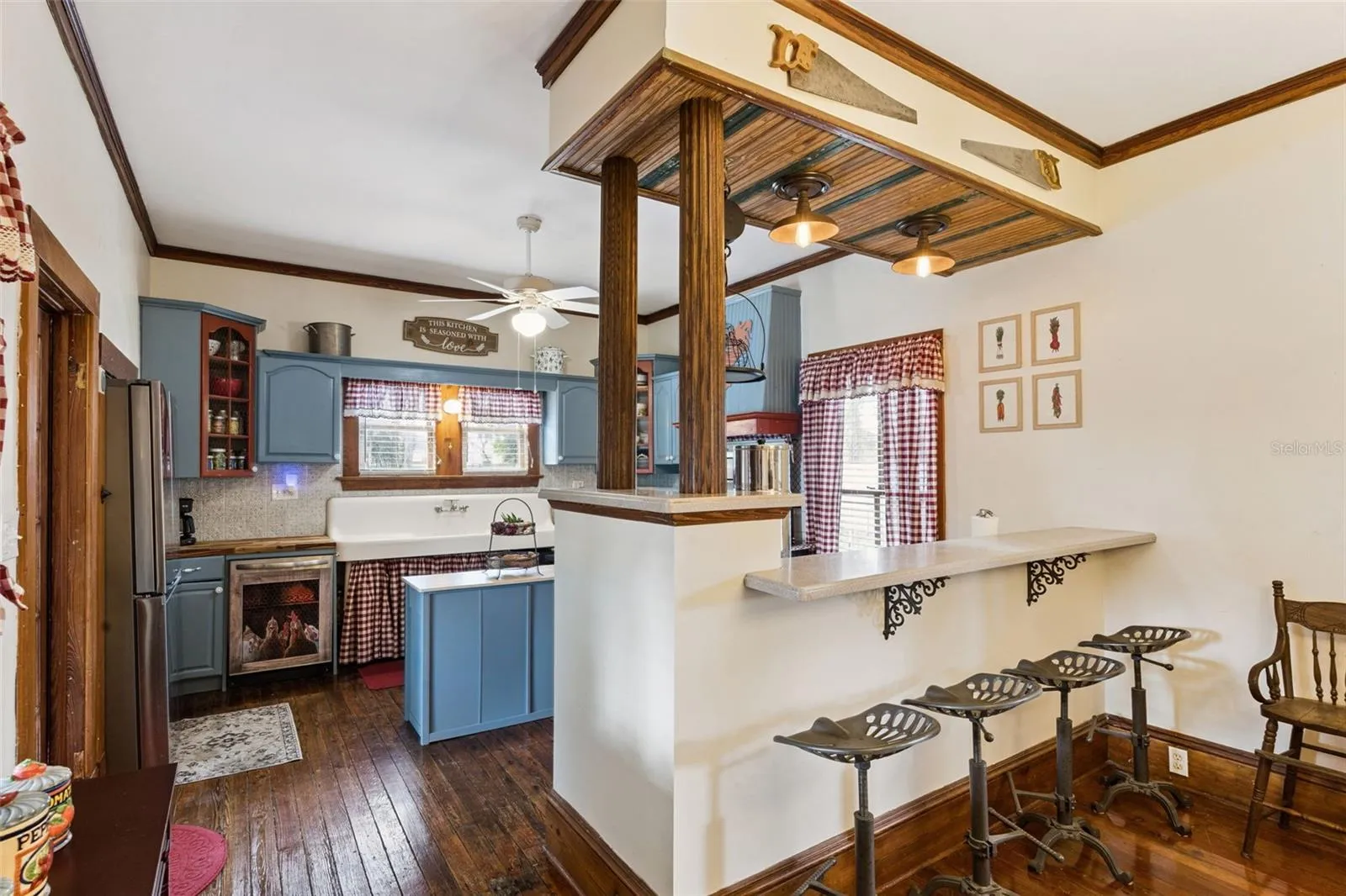 An open pass-through and breakfast bar connect the dining room and kitchen while preserving the character of each space.