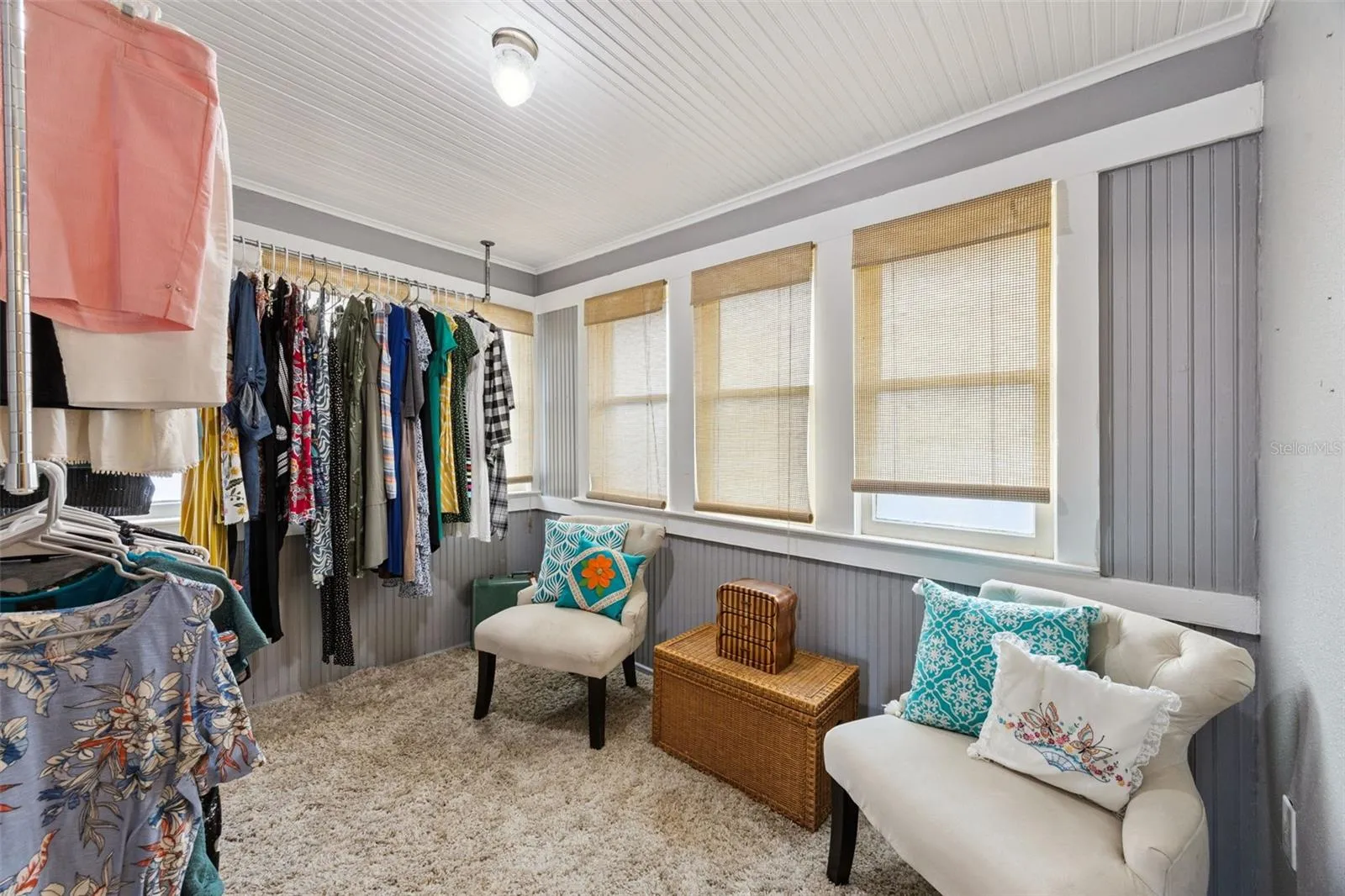 A former sleeping porch now offers wonderfully flexible bonus space — currently used as a dressing room and surrounded by windows.
